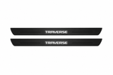 Catalogue illustration of two black Matte PRO front door sill plates with illuminated geometric TRAVERSE lettering on the upper surface. Thin decorative lines and edges are unlit; rear plates for FRONT+REAR are not pictured. Dimensions are selected for the Chevrolet Traverse C1XX during manufacture.