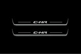 Two long door sill plates with C-HR lettering and edges illuminated in white, straight-on view on a dark background.