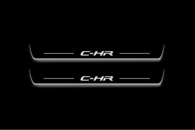 Two long door sill plates with C-HR lettering and edges illuminated in white, straight-on view on a dark background.