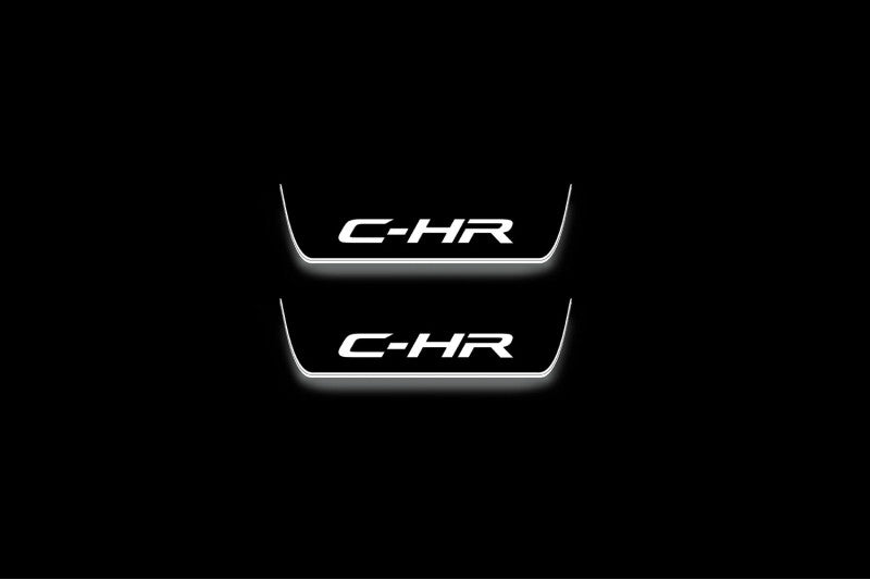 Two short door sill plates with C-HR lettering and edges illuminated in white, straight-on view on a dark background.