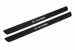 Catalogue illustration of two front black Matte PRO LED door sill plates with illuminated C-Elysee lettering for Citroen C-Elysee; dimensions are selected during manufacture.