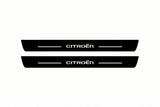 Shared catalogue illustration of two black Matte PRO front plates with illuminated stylized CITROËN lettering and two top lines, dark side edges. FRONT+REAR adds two rear plates not pictured; C4 B7 dimensions are selected during manufacture.