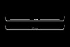 Two long door sill plates with C-Max lettering and edges illuminated in white, straight-on view on a dark background.