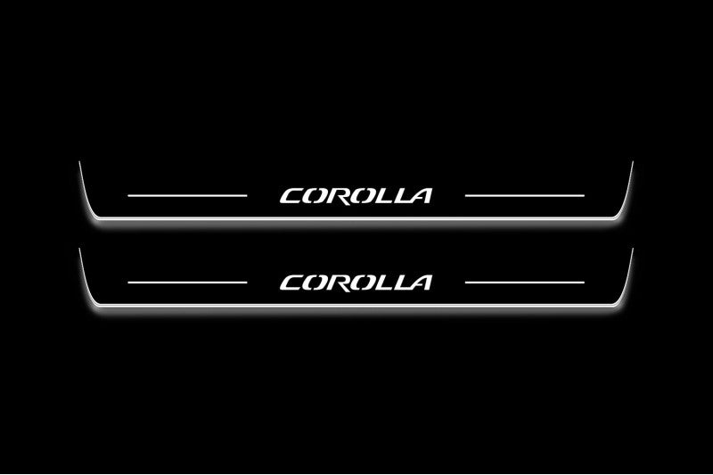Two long door sill plates with Corolla lettering and edges illuminated in white, straight-on view on a dark background.