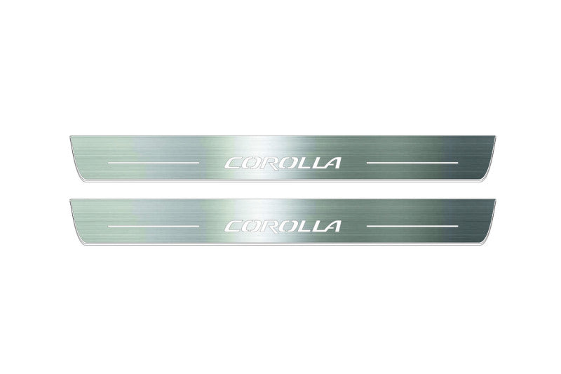 Two long silver-finished door sill plates with Corolla lettering on a light background, straight-on view.