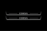 Two long door sill plates with Corsa lettering and edges illuminated in white, straight-on view on a dark background.