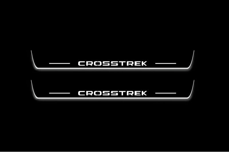 Two long door sill plates with Crosstrek lettering and edges illuminated in white, straight-on view on a dark background.