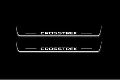 Two long door sill plates with Crosstrek lettering and edges illuminated in white, straight-on view on a dark background.