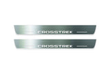 Two long silver-finished door sill plates with Crosstrek lettering on a light background, straight-on view.