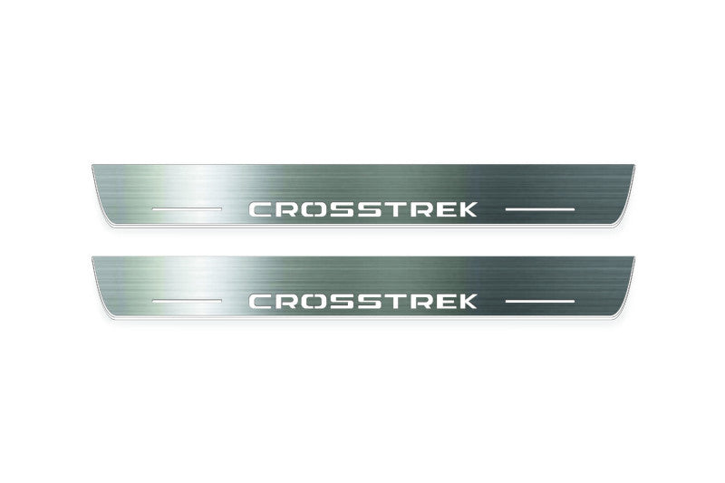 Two long silver-finished door sill plates with Crosstrek lettering on a light background, straight-on view.