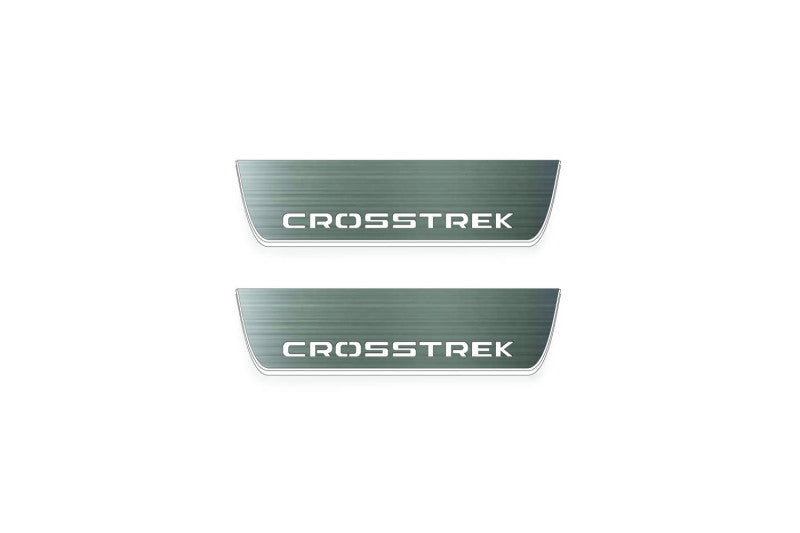 Two short silver-finished door sill plates with Crosstrek lettering on a light background, straight-on view.