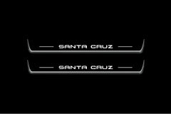 Two long door sill plates with Santa Cruz lettering and edges illuminated in white, straight-on view on a dark background.