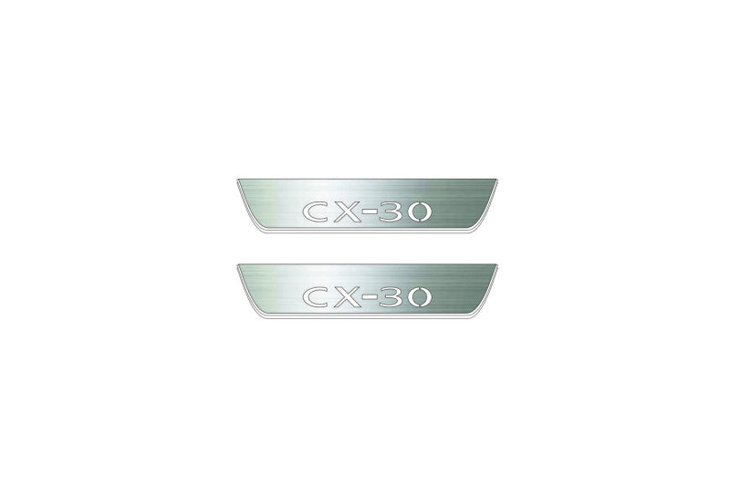 Two short silver-finished door sill plates with CX-30 lettering on a light background, straight-on view.