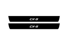 Catalog illustration of two black front door sill plates with CX-5 lettering.