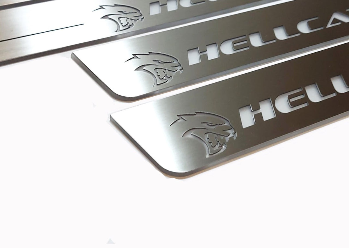 Close-up of Hellcat lettering and head emblems on silver-finished door sill plates.