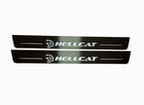 Two long dark reflective door sill plates with white Hellcat lettering and head emblems.