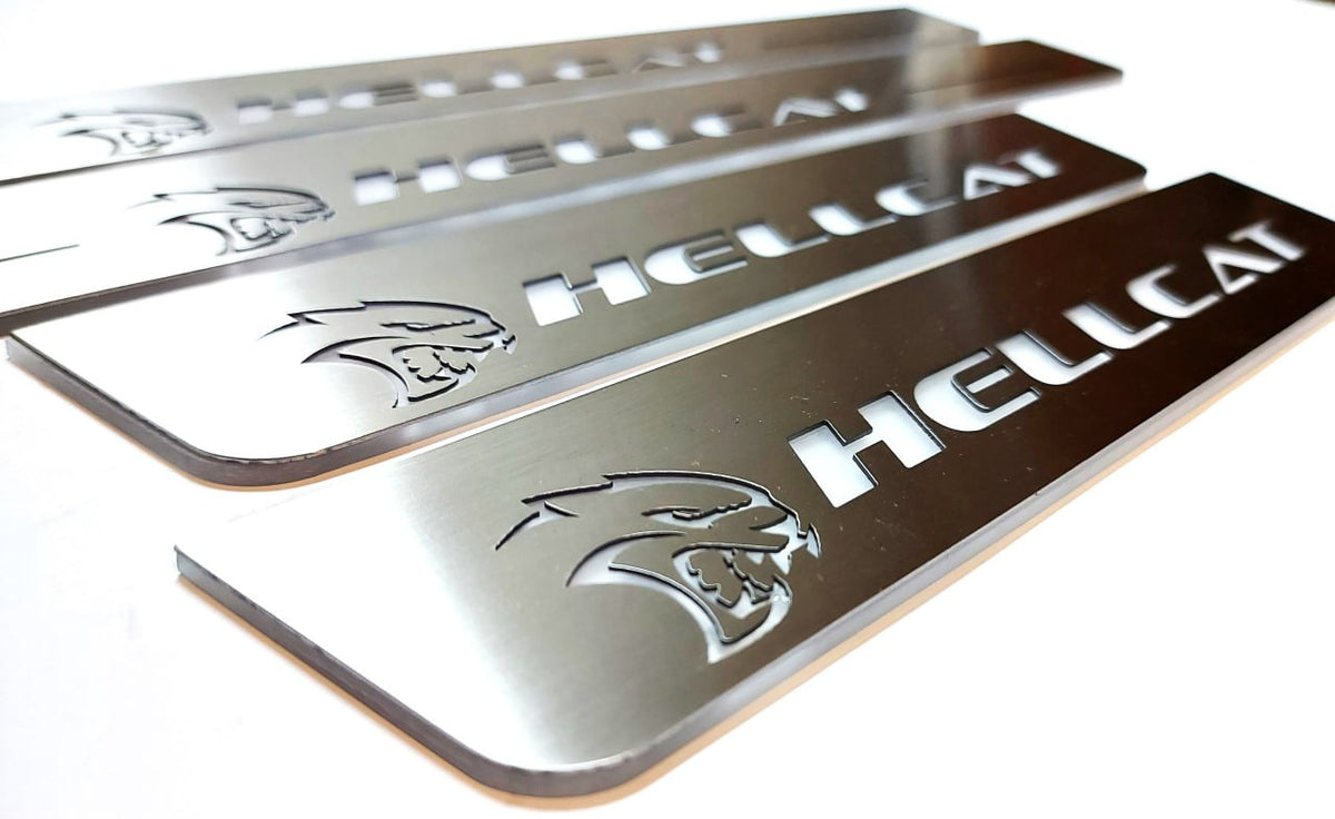 Close-up of Hellcat lettering and head emblems on silver-finished door sill plates.