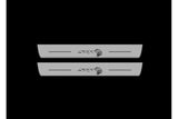 Catalog illustration of two long gray door sill plates with SRT lettering and Hellcat-head emblems on a black background.