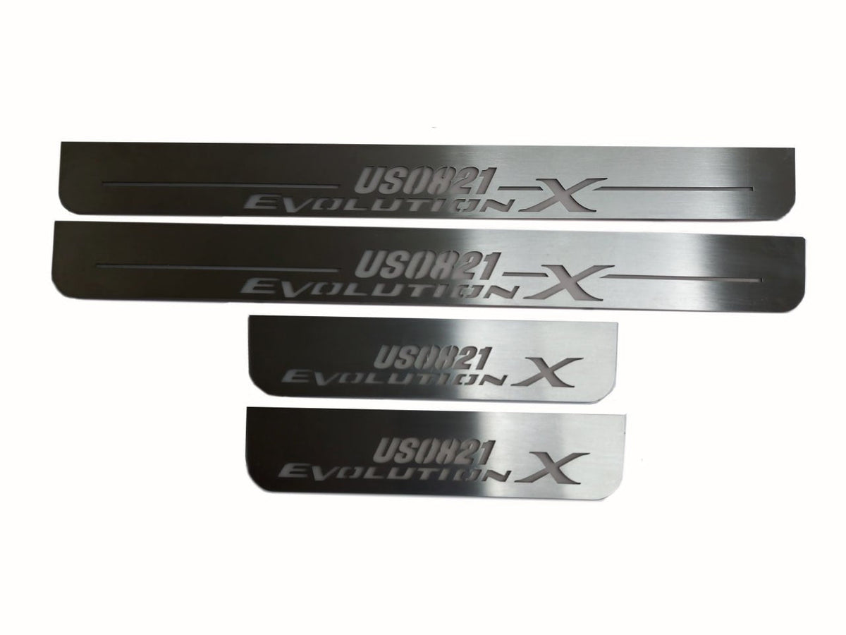 Four silver-finished door sill plates with USDM21 Evolution X lettering.