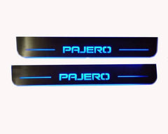 Two long reflective door sill plates with blue Pajero lettering and horizontal lines.