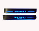Two long reflective door sill plates with blue Pajero lettering and horizontal lines.