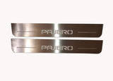 Two long silver-finished door sill plates with Pajero lettering on a light background, straight-on view.