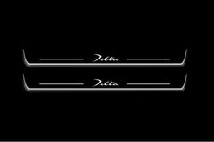 Two long door sill plates with Delta lettering and edges illuminated in white, straight-on view on a dark background.