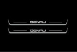 Two long door sill plates with Denali lettering and edges illuminated in white, straight-on view on a dark background.