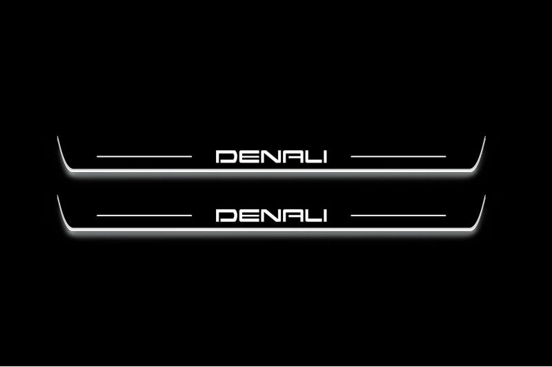 Two long door sill plates with Denali lettering and edges illuminated in white, straight-on view on a dark background.