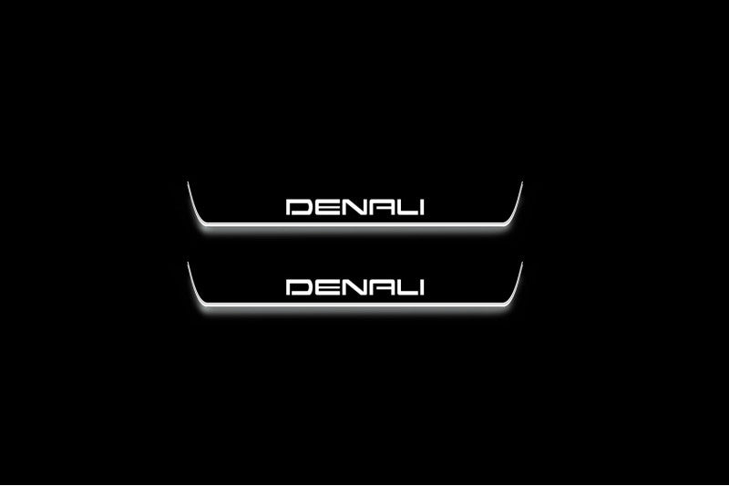 Two short door sill plates with Denali lettering and edges illuminated in white, straight-on view on a dark background.
