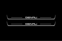 Two long door sill plates with Denali lettering and edges illuminated in white, straight-on view on a dark background.