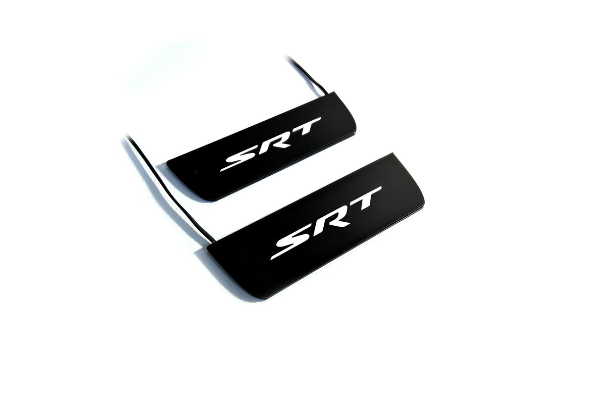 Two black door sill plates with white SRT lettering and visible wiring on a light background.