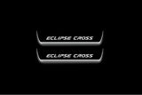 Two short door sill plates with Eclipse Cross lettering and edges illuminated in white, straight-on view on a dark background.