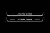 Two long door sill plates with Eclipse Cross lettering and edges illuminated in white, straight-on view on a dark background.