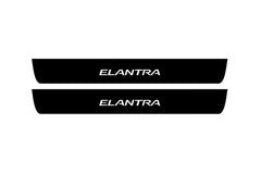 Catalog illustration of two black front door sill plates with Elantra lettering.