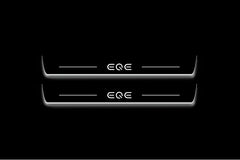 Two long door sill plates with EQE lettering and edges illuminated in white, straight-on view on a dark background.