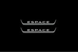 Two short door sill plates with Espace lettering and edges illuminated in white, straight-on view on a dark background.