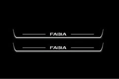 Two long door sill plates with Fabia lettering and edges illuminated in white, straight-on view on a dark background.