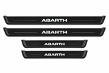 Catalogue illustration of two long black Matte PRO front plates and two shorter rear plates with ABARTH inscription illuminated on top. Side edges unlit; not exact vehicle dimensions. FRONT option includes front plates only.