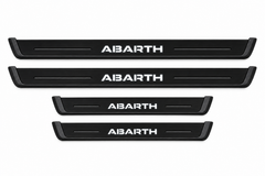 Catalogue illustration of two long black Matte PRO front plates and two shorter rear plates with ABARTH inscription illuminated on top. Side edges unlit; not exact vehicle dimensions. FRONT option includes front plates only.