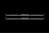 Two long door sill plates with Forester lettering and edges illuminated in white, straight-on view on a dark background.
