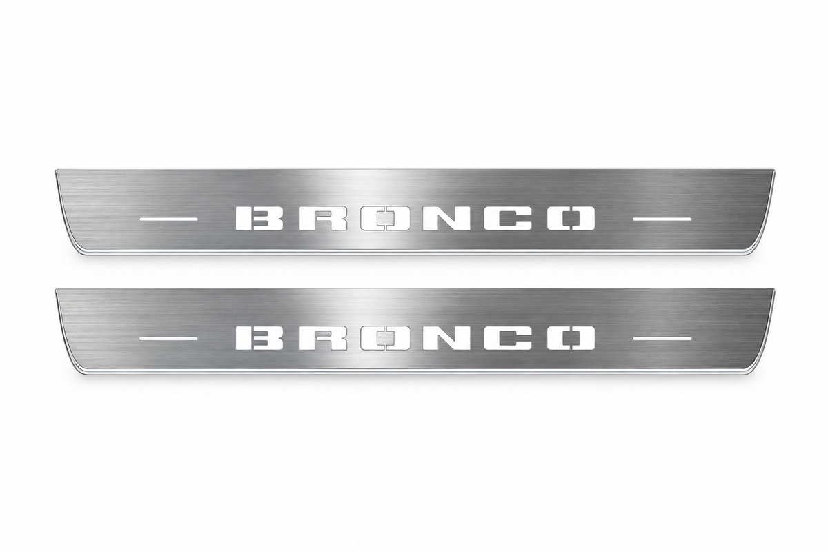 Product visualization: two exact short-proportion front plates with original BRONCO stencil letters flat brushed stainless steel door sill plates with white LED artwork and edges, white background.