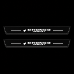 Catalogue illustration of two black Matte PRO front door sill plates with a small horse symbol and stacked illuminated BRONCO SPORT lettering on the top surface. Rear plates are not pictured; dimensions are selected for the vehicle during manufacture.