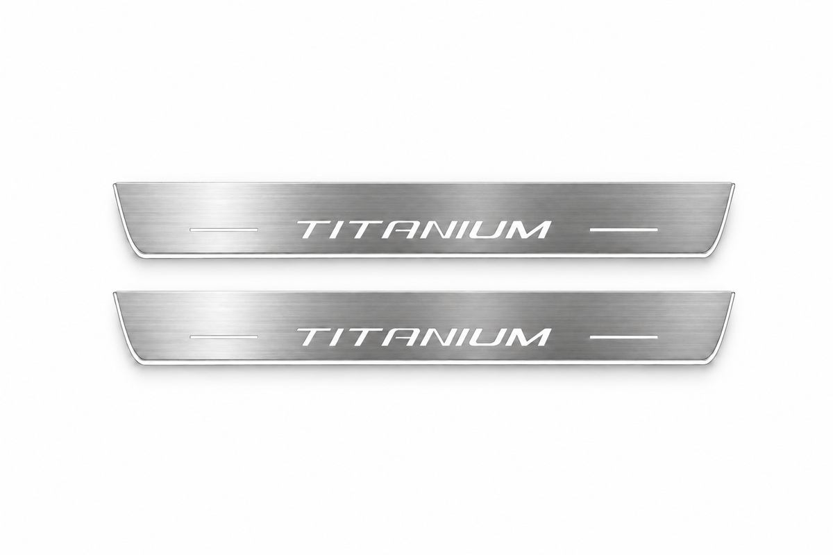 Product visualization: two Ford Edge Titanium FRONT flat brushed stainless steel door sill plates with white LED artwork and edges, white background.