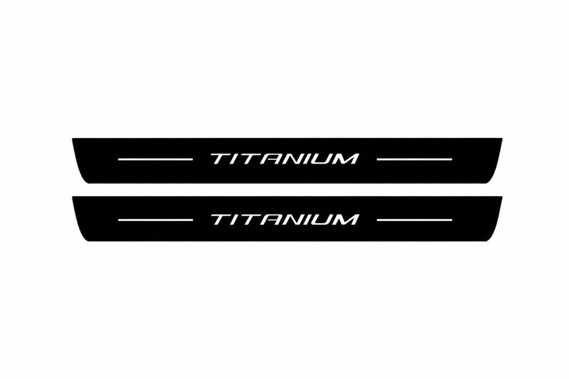 Shared catalogue illustration of two black Matte PRO front plates with illuminated Titanium lettering and unlit edges. FRONT+REAR also includes two rear plates not shown; exact Ford Escape C520 dimensions are selected during manufacture.