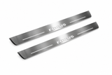 Product visualization: two exact focus-ii-block-diagonal flat Stainless front plates, own source geometry and lettering; hidden night metal, white LED zones flat brushed stainless steel door sill plates with white LED artwork and edges, white background.