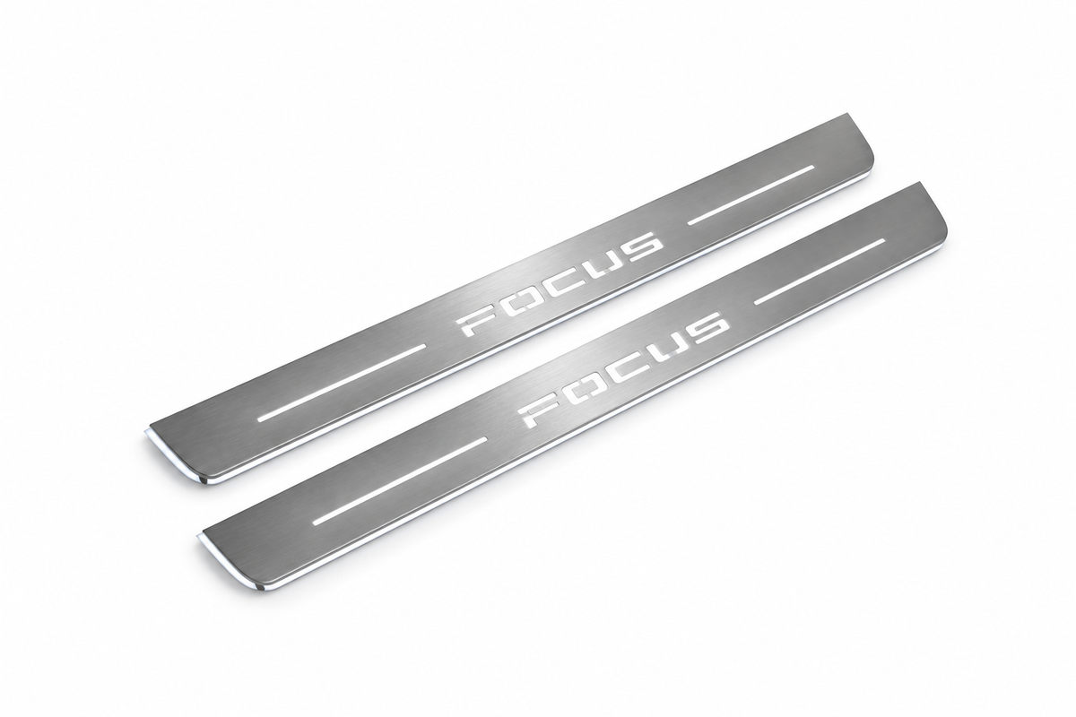 Product visualization: two exact focus-iv-diagonal flat Stainless front sill plates with original artwork, neutral white LEDs and own thin-edge geometry flat brushed stainless steel door sill plates with white LED artwork and edges, white background.