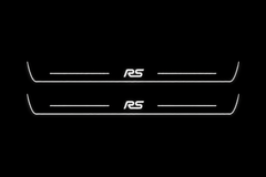 Product visualization: two Ford Focus RS front plates, exact original RS logo and bars; main metal hidden in black night lighting, white LED art and side/end edges; white secondary shows silver metal flat brushed stainless steel door sill plates with white LED artwork and edges, dark background.