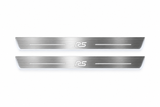 Product visualization: two Ford Focus RS front plates, exact original RS logo and bars; main metal hidden in black night lighting, white LED art and side/end edges; white secondary shows silver metal flat brushed stainless steel door sill plates with white LED artwork and edges, white background.
