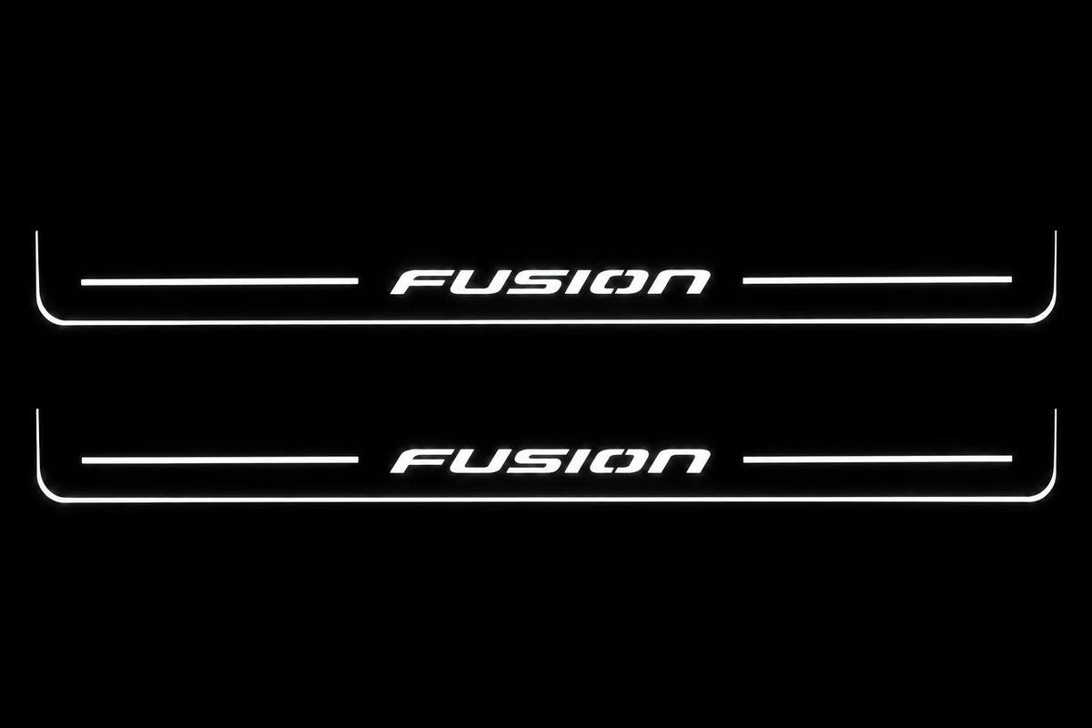 Front Pair: two front Stainless steel Fusion door sill plates with white illuminated Fusion artwork, stripes and edges on a black night background.